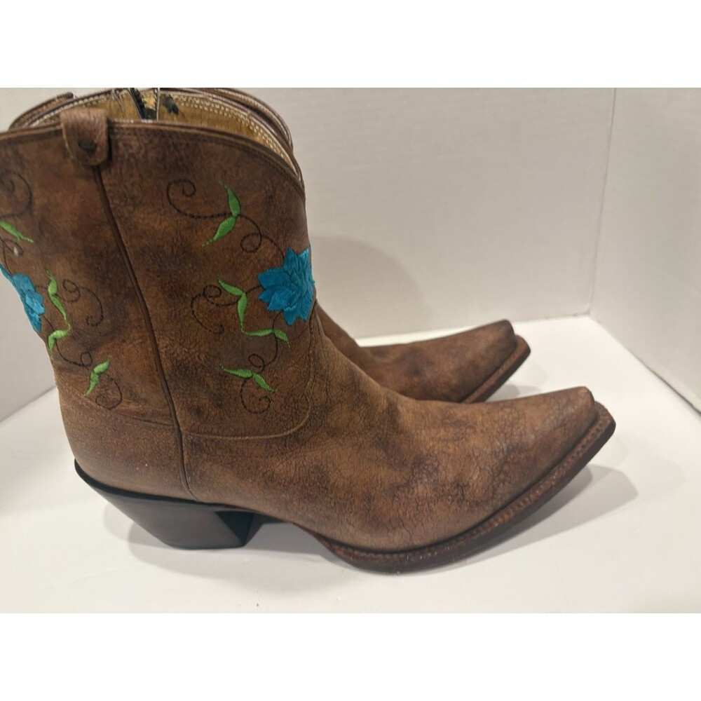 Tony Lama ankle boots with turquoise floral embroidery and side zippers.